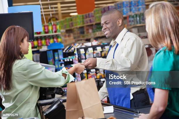 Freundliche Lebensmittelgeschäft Clerk Gibt Zum Kunden Stockfoto und mehr Bilder von Geldschein