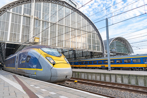 Eurostar high speed train leaving Amsterdam Central Station for London St. Pancras station during a summer day.