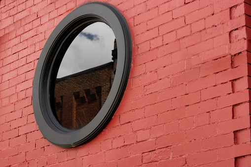 Close up of an Exterior Wall of a painted red brick building with a round window in downtown Knoxville, TN.
