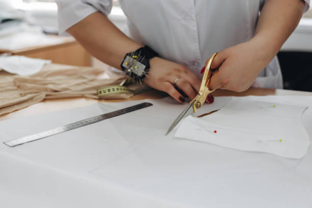 istock A person is taking measurements and cutting something with scissors. 1479710346