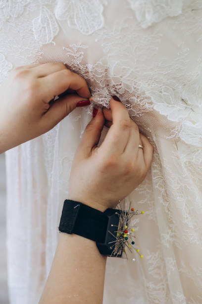 istock A professional designer is crafting a white dress and sewing on it. 1479710408