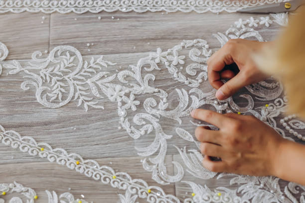 istock The tailor is correcting her white ornament for the future wedding dress. 1479710465