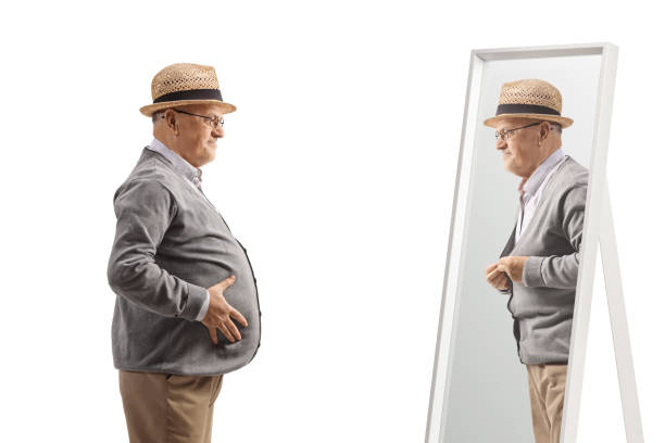 istock Elderly man with a big belly in front of a mirror 1479712332