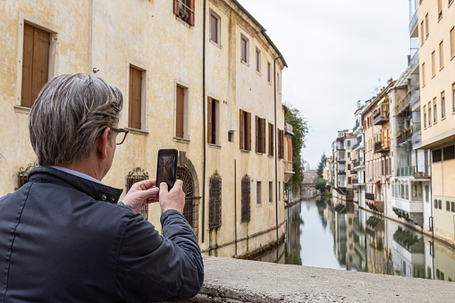 Padua, Veneto, Italy - Mar 11th, 2023: Tourist taking photos at Ponte delle Torricelle in Padua city center