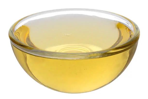 Agave syrup in a glass bowl isolated on white.