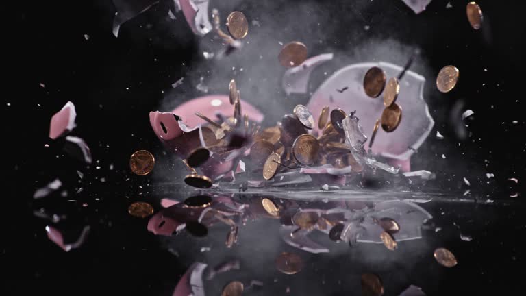 SLO MO LD Piggy bank exploding and coins flying into the air