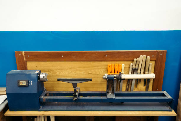 Wood lathe stands in carpentry shop. Background. Milling machine with tools for processing wooden products stands against wall. Copy space..