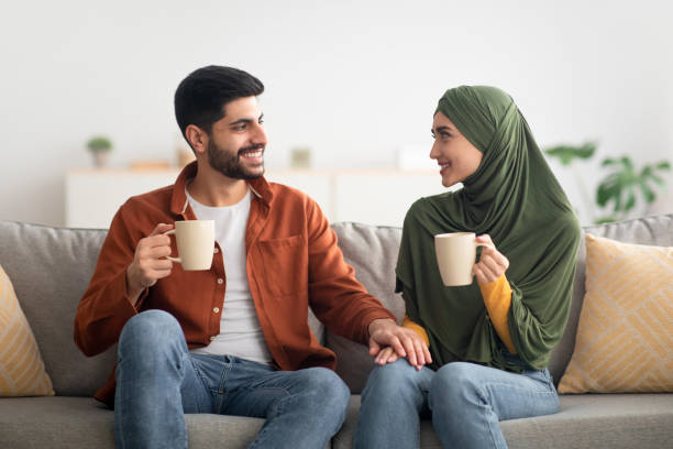 istock Cheerful Muslim Spouses Drinking Coffee Together Sitting At Home 1479720808