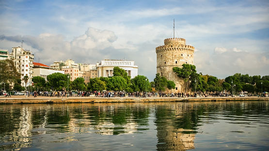 Panoramic view and reflection of White Tower in Thessaloniki or Saloniki capital of Macedonia Greece, walking pedestrians.