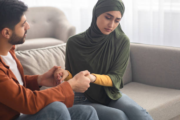 istock Unhappy Middle Eastern Couple Holding Hands Sitting On Sofa Indoors 1479721233