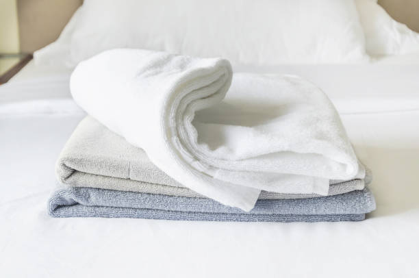 istock three folded clean terry towels on white background. stack of towels in pastel colors on bedsheet 1479724255