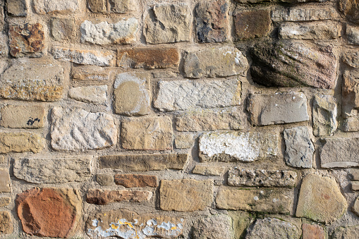 Background Exterior stone blocks wall of crumpling old building in ghost town located in north central Montana, western USA.