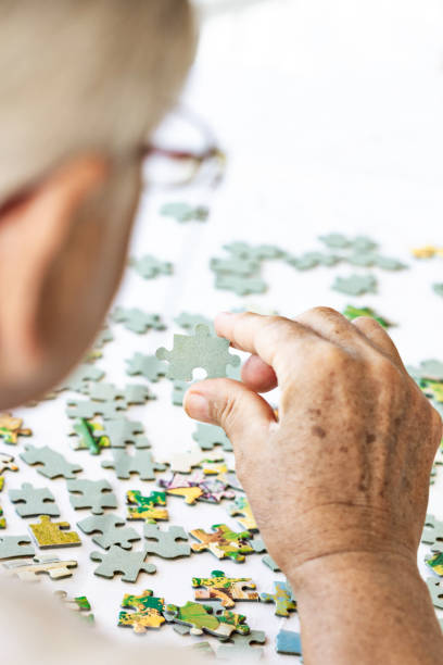 istock Senior Woman is Playing Puzzle. 1479726487