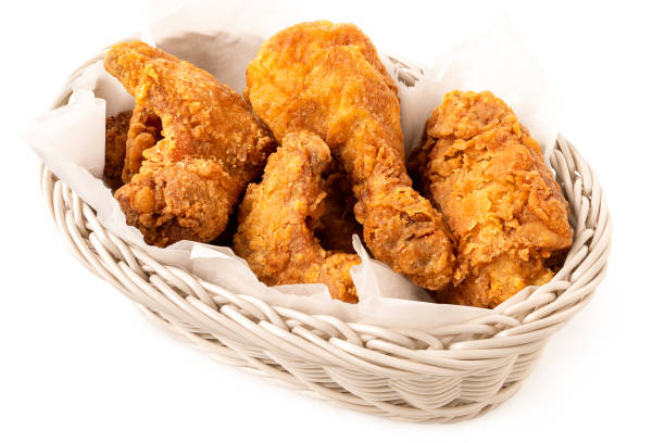 istock Crispy fried chicken pieces in a white woven basket isolated on white. 1479728993