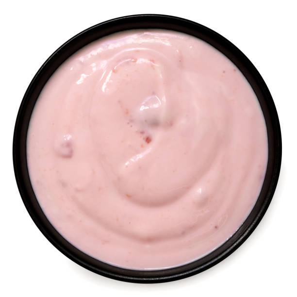istock Strawberry yogurt in a black ceramic bowl isolated on white from above. 1479731501