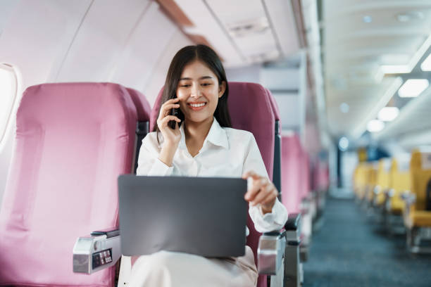 istock Asian business woman passenger sitting on business class luxury plane while working using smart phone mobile talking or video conference and travel concept 1479731872