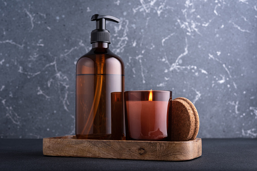 Spa composition with burning candle and recycled dispenser bottles for natural cosmetic