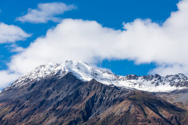 A striking landscape features a snow-capped mountain, standing tall and majestic in its solitude.