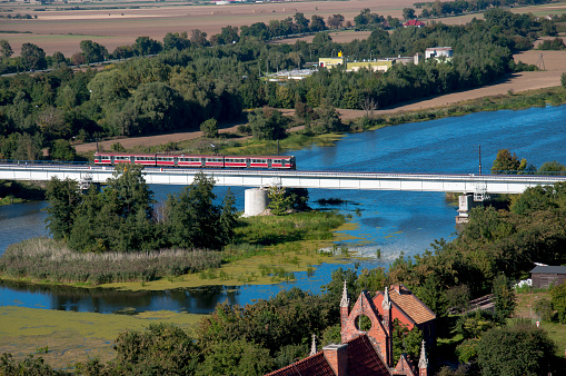 Malbork view of a red train and bridge over the river and forest landscape beautiful