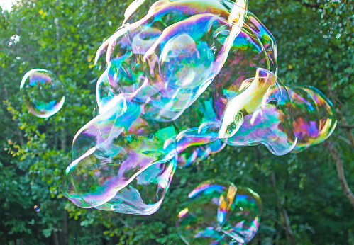 Young woman blowing soap bubbles in the park stock photo