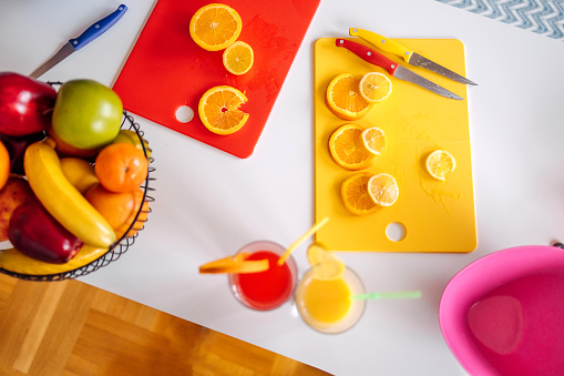 Woman making juice at home using orange and lemon fruit