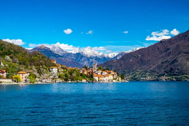The village of Santa Maria Rezzonico, on Lake Como, photographed on a spring day, with its tower and the Alps in the background.