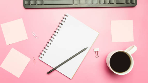 istock Office table in pastel pink colors with laptop, keyboard, coffee cup and notebook. Top view, copy space, flat lay. 1479744205