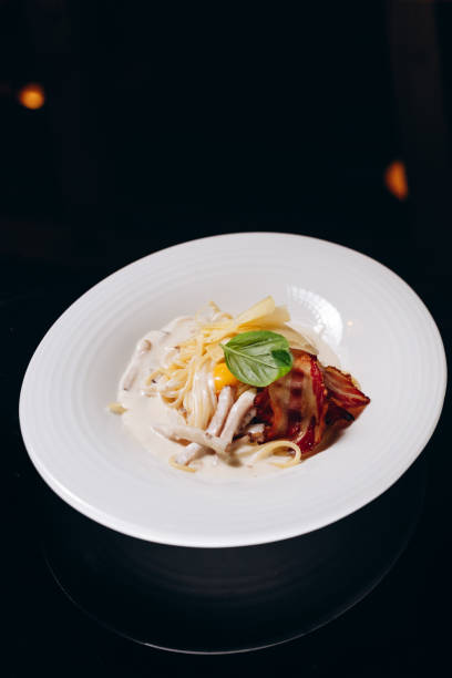 istock Carbonara pasta with bacon and cream sauce. Decorated with egg yolk and basil. 1479747764