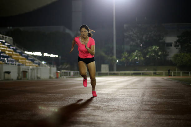 An Asian young woman is speed running for upcoming track and field 100m race