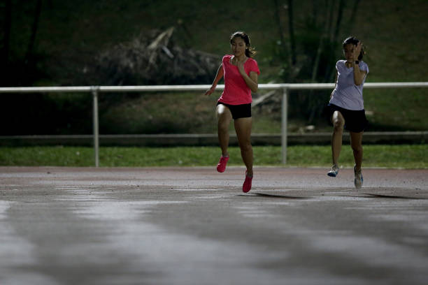 Asian young women are speed running for upcoming track and field 100m race