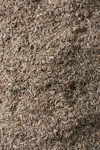 pile of paddy husk, aka yellow rice chaff, rice husk or hull, outermost layer of the grain mixed with soil to use as animal feed, selective focus in full frame