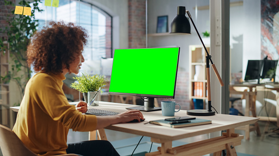 Confident Arab Businesswoman Working on Implementing Modern Business Strategy in Creative Agency. Specialist Writing Corporate Project Plan on Desktop Computer with Green Screen Mock Up Display.