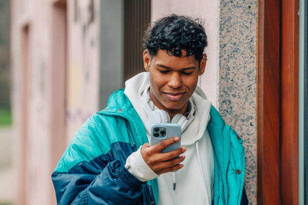 istock young latino man walking with mobile phone 1479756428