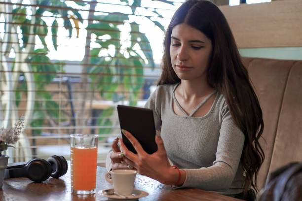 Smiling Female Setting Up Her Playlist On Digital Tablet
