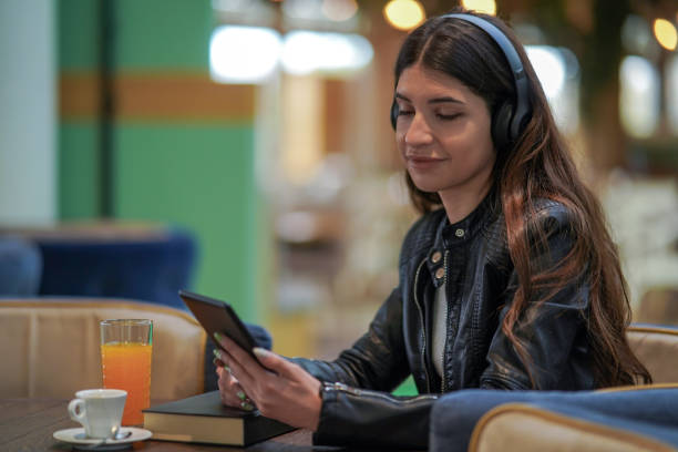 istock Smiling Female Setting Up Her Playlist On Digital Tablet 1479760584