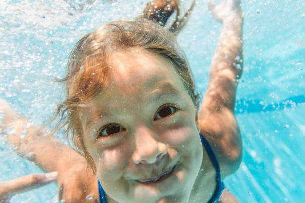 istock Little girl having fun diving underwater 1479761304
