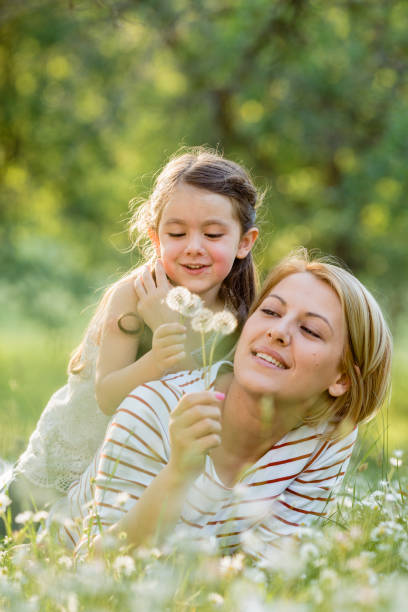 istock Mother and child having fun blowing dandelion seeds 1479761866