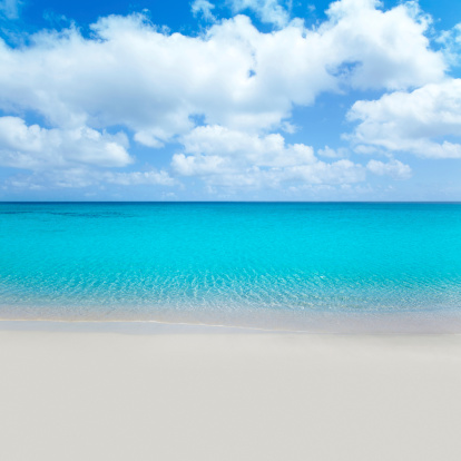 beach tropical with white sand and turquoise water under blue sky. Sky is photomount so image is not resized