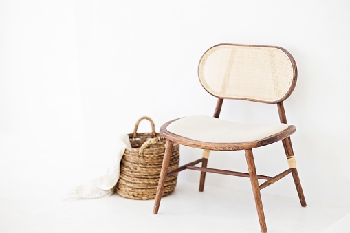 Light rattan chair and a whicker basket with a blanket