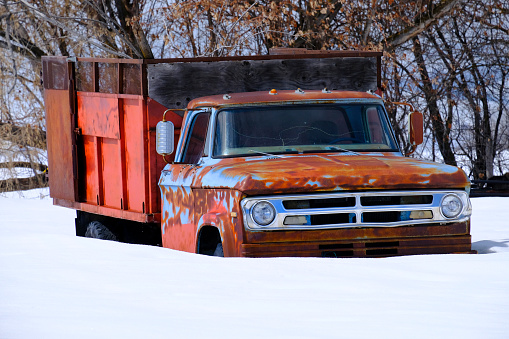 Old work truck worktruck buried in deep snow after winter storm snowstorm