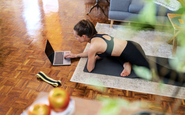 istock Athletic woman doing yoga training at home and using her laptop 1479770140