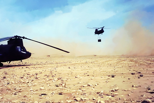 FOB (forward operating base),  Saudi Arabia - January 27, 1991: A U.S. Army CH-47D Chinook helicopter from the 101st Airborne Division hauls an external sling load (attached to cargo hooks underneath the aircraft) from a desert FOB in Saudi Arabia on the border with Iraq less than a week before the ground- war phase of the Persian Gulf War begins.