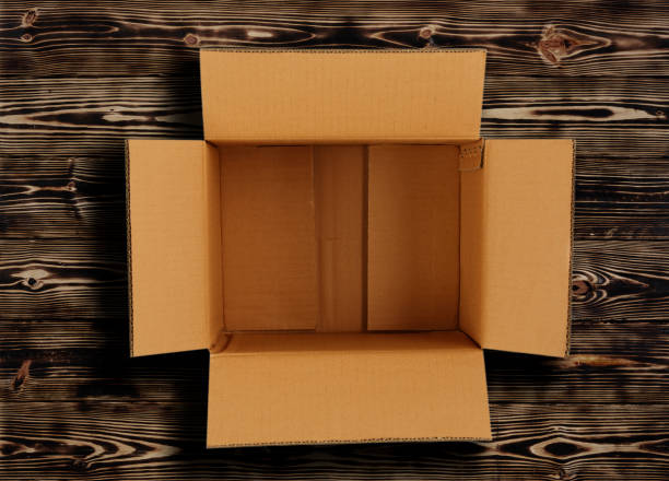 istock Opened cartoon box isolated on wooden background. 1479771435