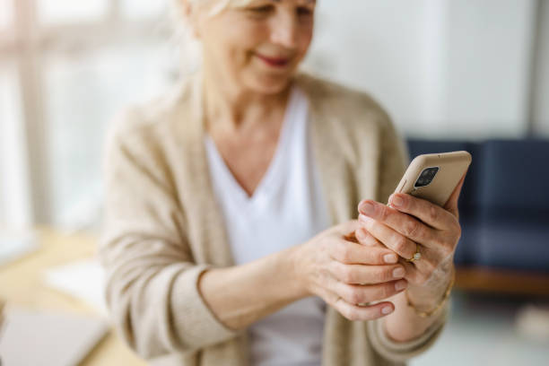 istock Smiling senior woman using smartphone 1479773901