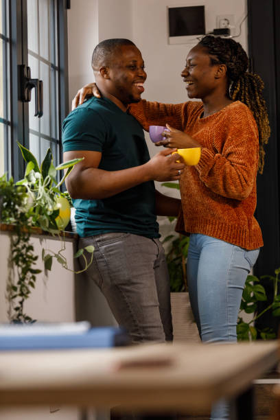 istock Couple standing face to face, embraced, smiling at each other while enjoying coffee 1479777162