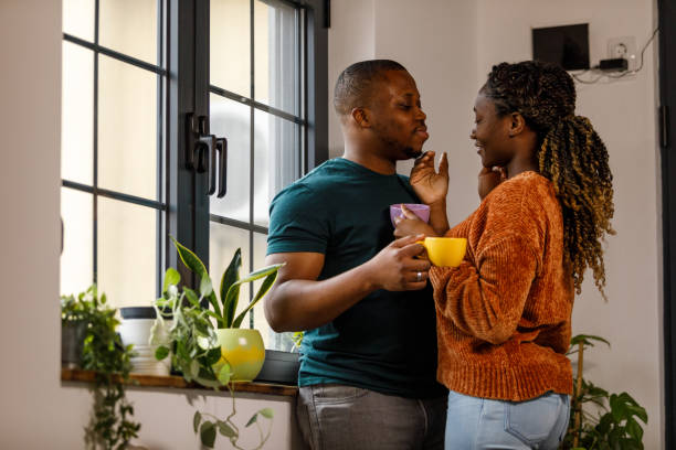 istock Couple standing face to face, embraced, smiling at each other while enjoying coffee 1479777172