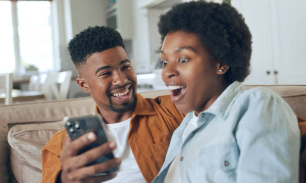 istock Young happy couple having fun using smartphone at home 1479777969
