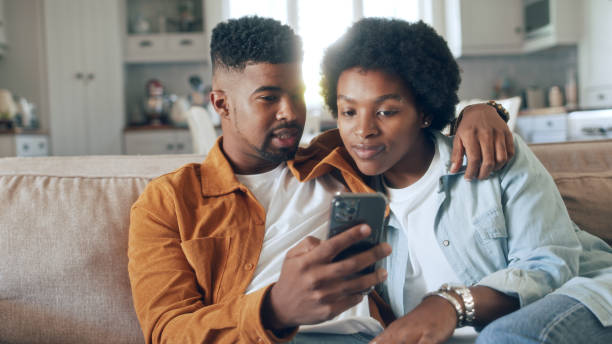 istock Young happy couple having fun using smartphone at home 1479777971