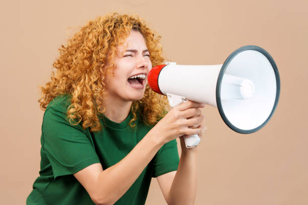 istock Curly-haired woman angry shouting over a loudspeaker 1479778201
