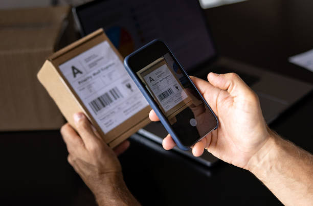 istock Close-up on a man working at home shipping some packages using a mobile app 1479782206
